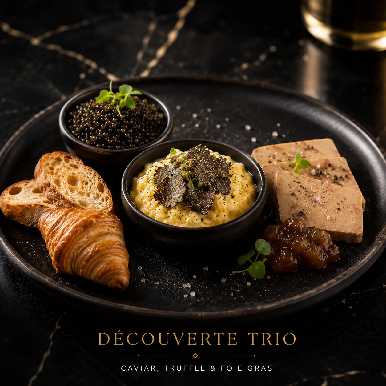 The Découverte Trio — Kaluga caviar, truffled scrambled eggs and foie gras on a black plate