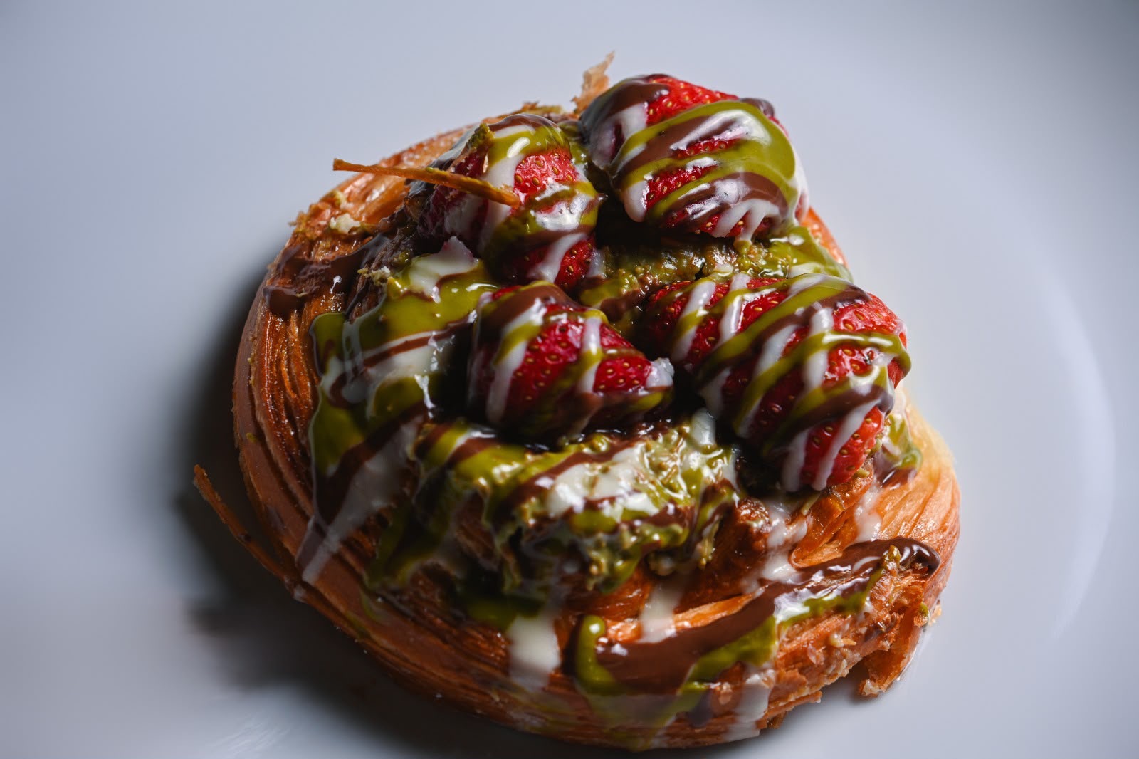 Dubai danish crowned with strawberries, pistachio cream and chocolate drizzle
